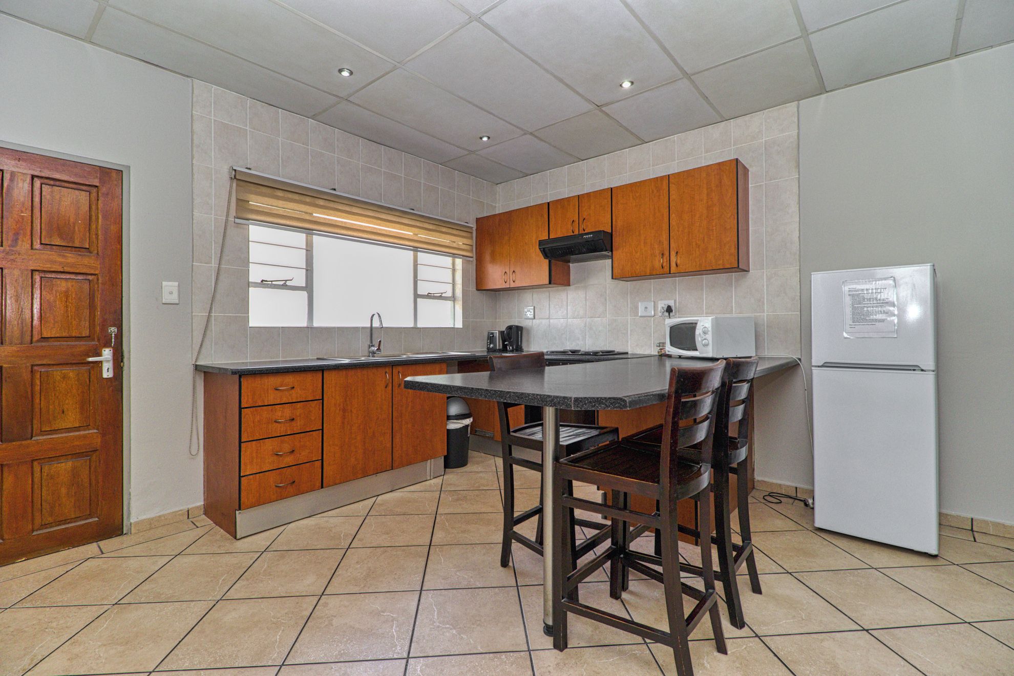 A kitchen with a built-in stove, a microwave, and a refrigerator.