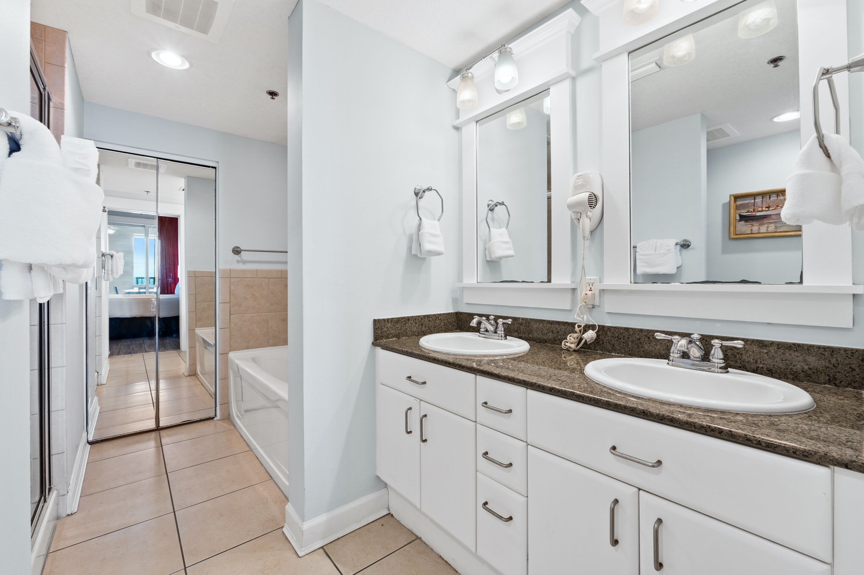 Une salle de bain moderne avec deux lavabos, un grand miroir et une douche à l’italienne.