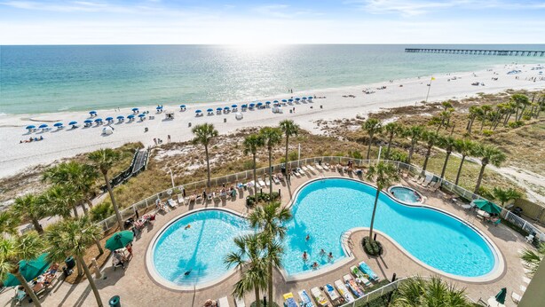 A resort with a large pool, beach access, and a pier in the background. - Grand Panama Beach Resort by Panhandle Getaways (Panama City Beach)