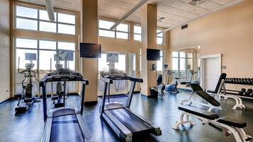A gym with treadmills, elliptical machines, and weight benches.