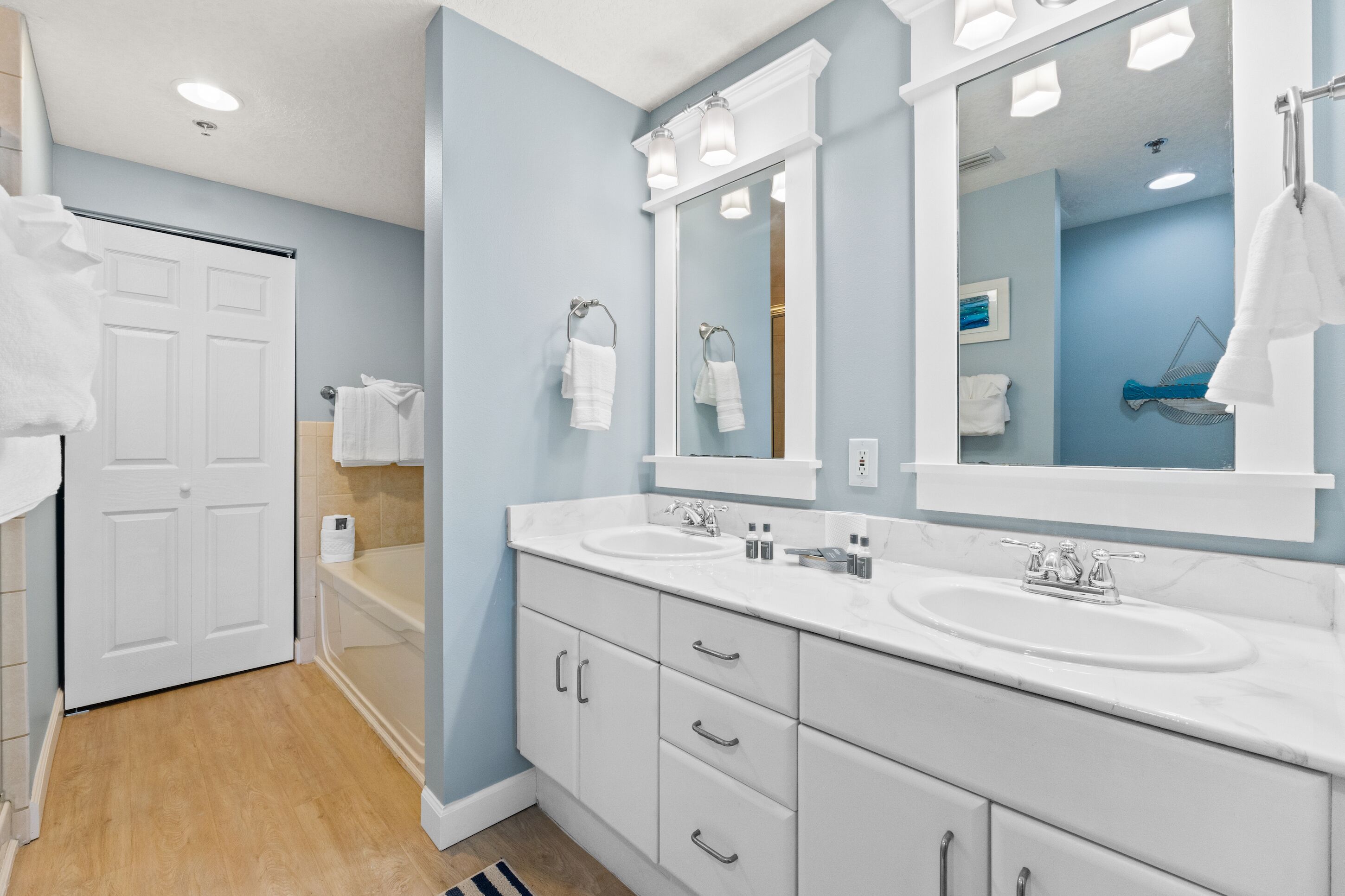 A modern bathroom with two sinks, a large mirror, and a shower area.