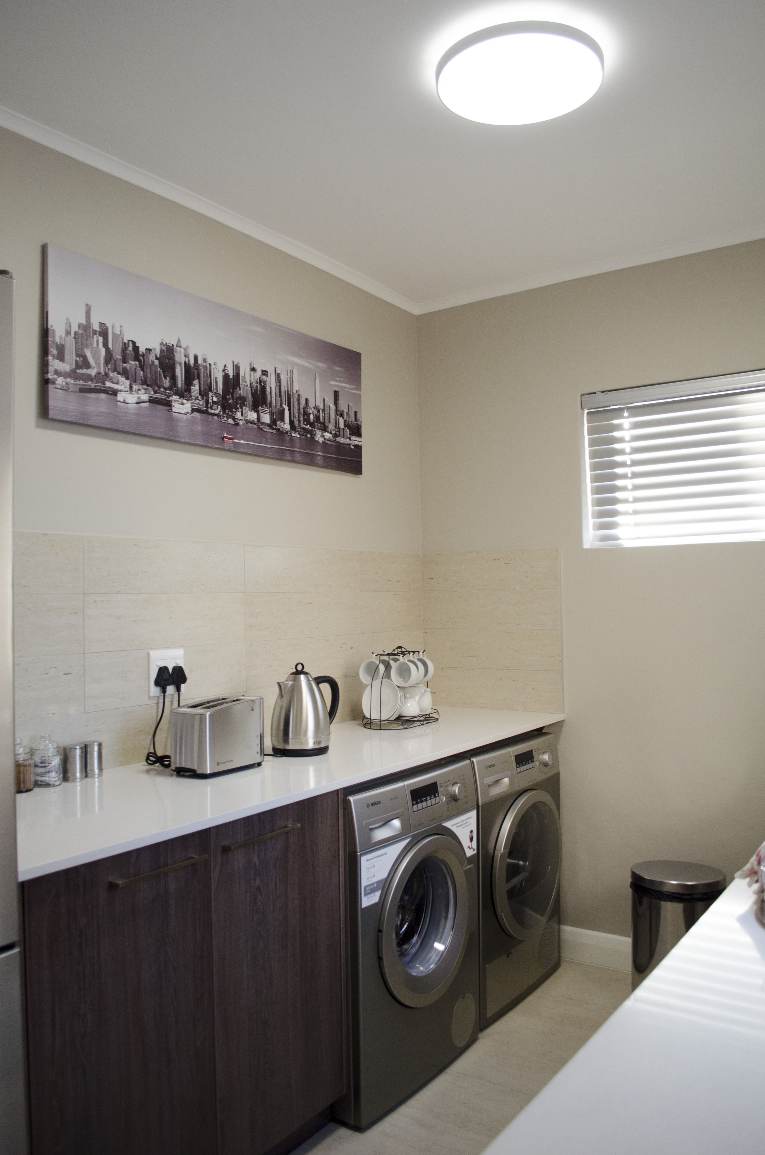 A compact laundry area with a washing machine, dryer, and a toaster on the counter.