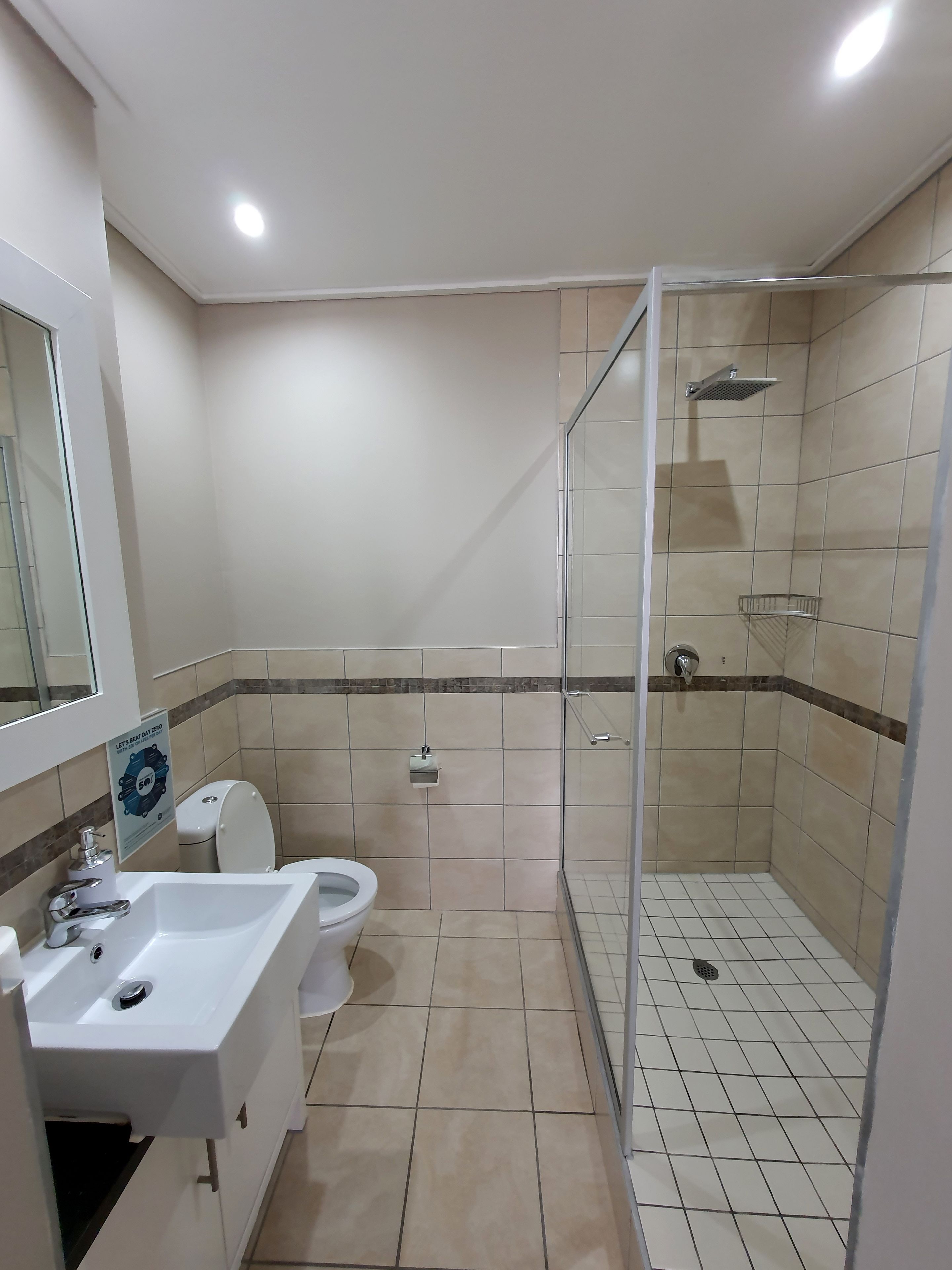 A bathroom with a shower, toilet, and sink.