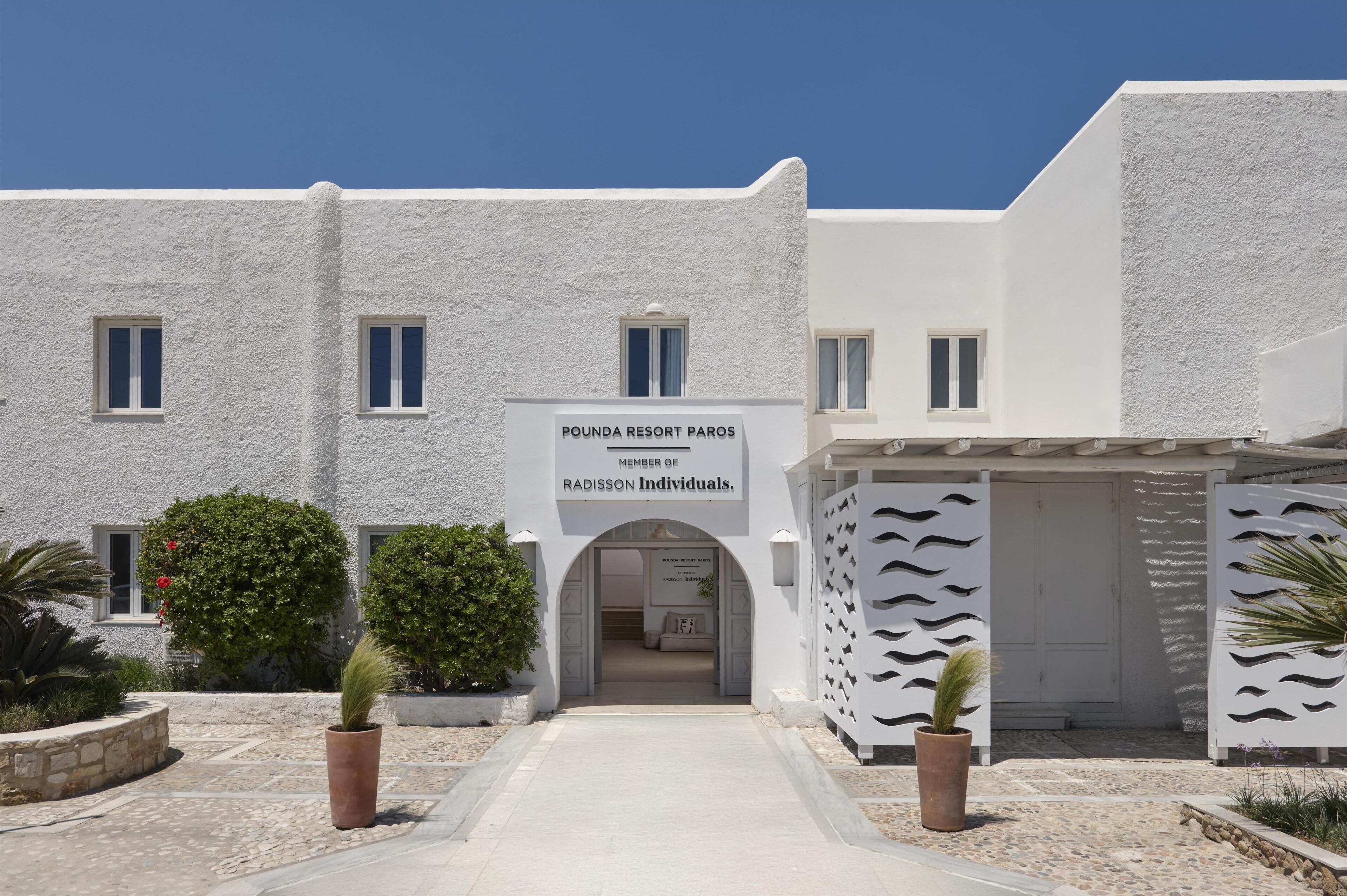 A building with a sign reading 'POUNDA RESORT PAROS' and 'MEMBER OF RADISSON INDIVIDUALS.'