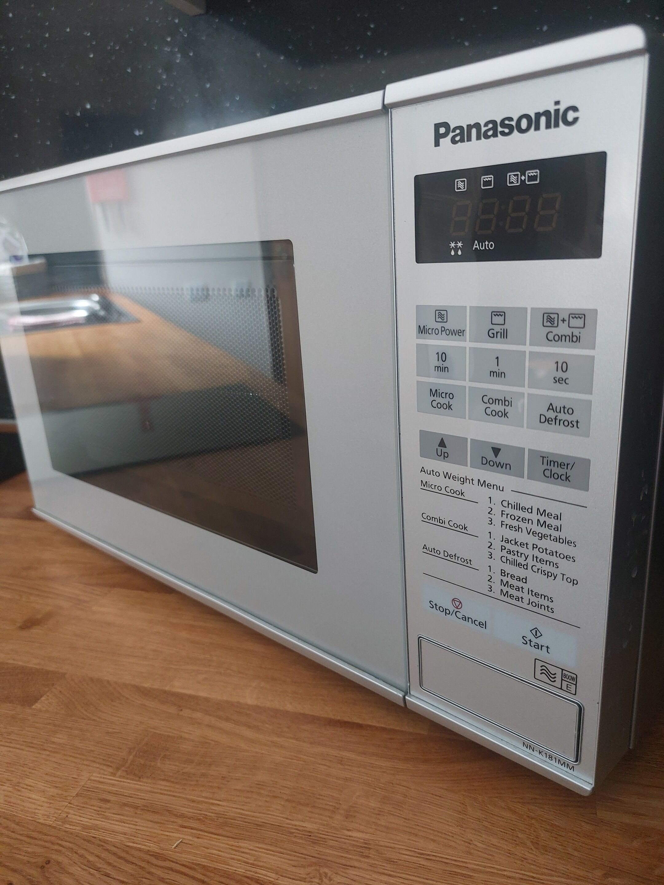 Een Panasonic magnetron met een digitaal display, bedieningspaneel en een indicator voor het vermogen.