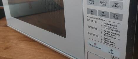 Een Panasonic magnetron met een digitaal display, bedieningspaneel en een indicator voor het vermogen.