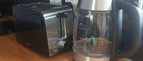 A toaster and a coffee maker on a wooden countertop.