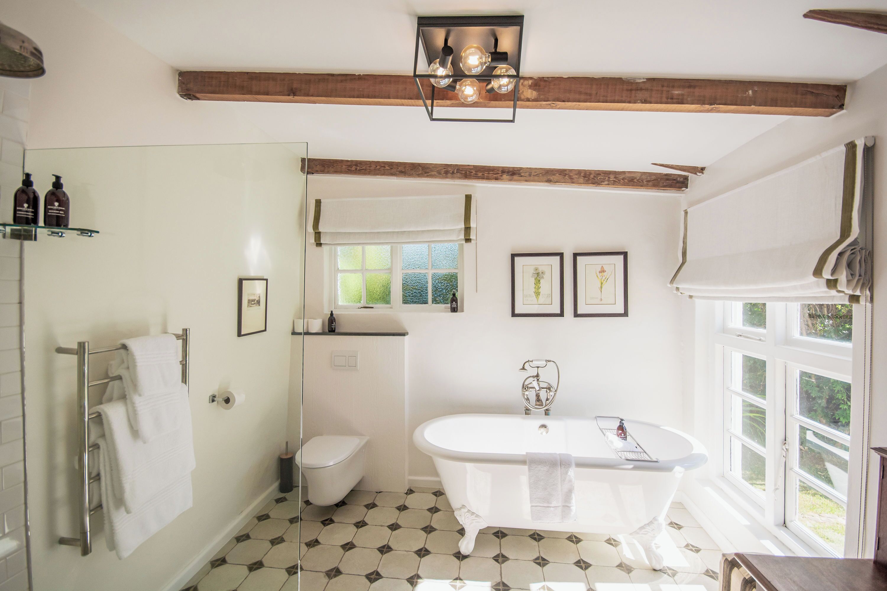 A bathroom with a freestanding bathtub, a toilet, and a glass shower enclosure.