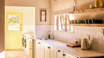 Una cucina con lavello, bollitore e finestra.