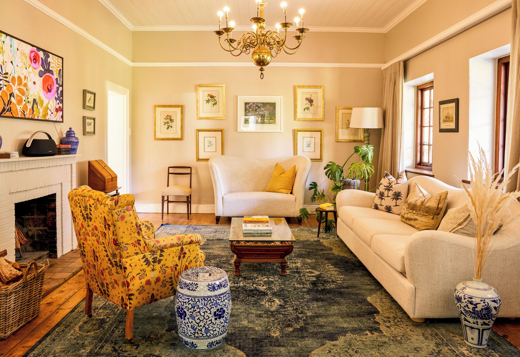 A living room with a fireplace, a sofa, a chair, a coffee table, and a chandelier.
