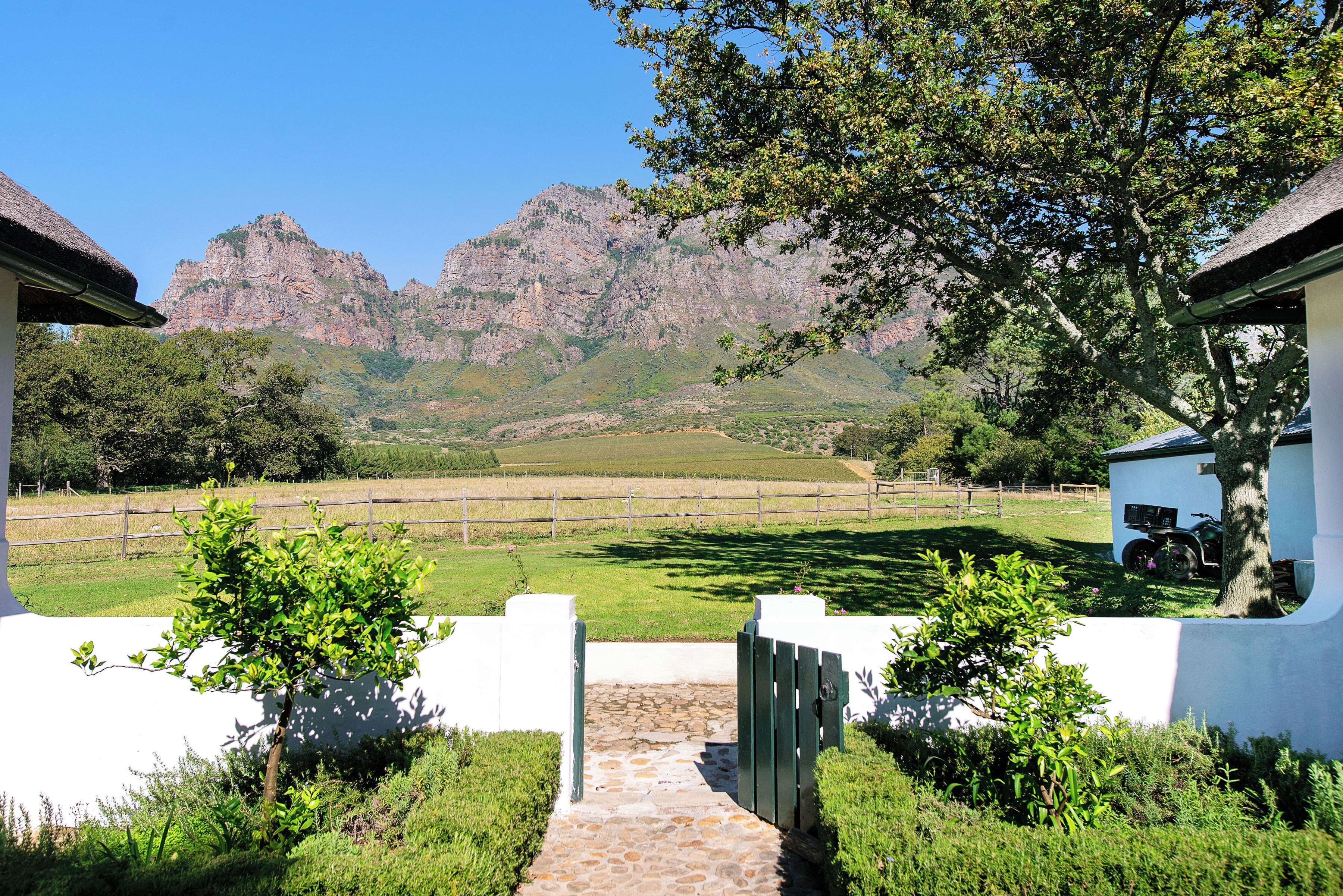A pathway leading to a building with a mountain backdrop.