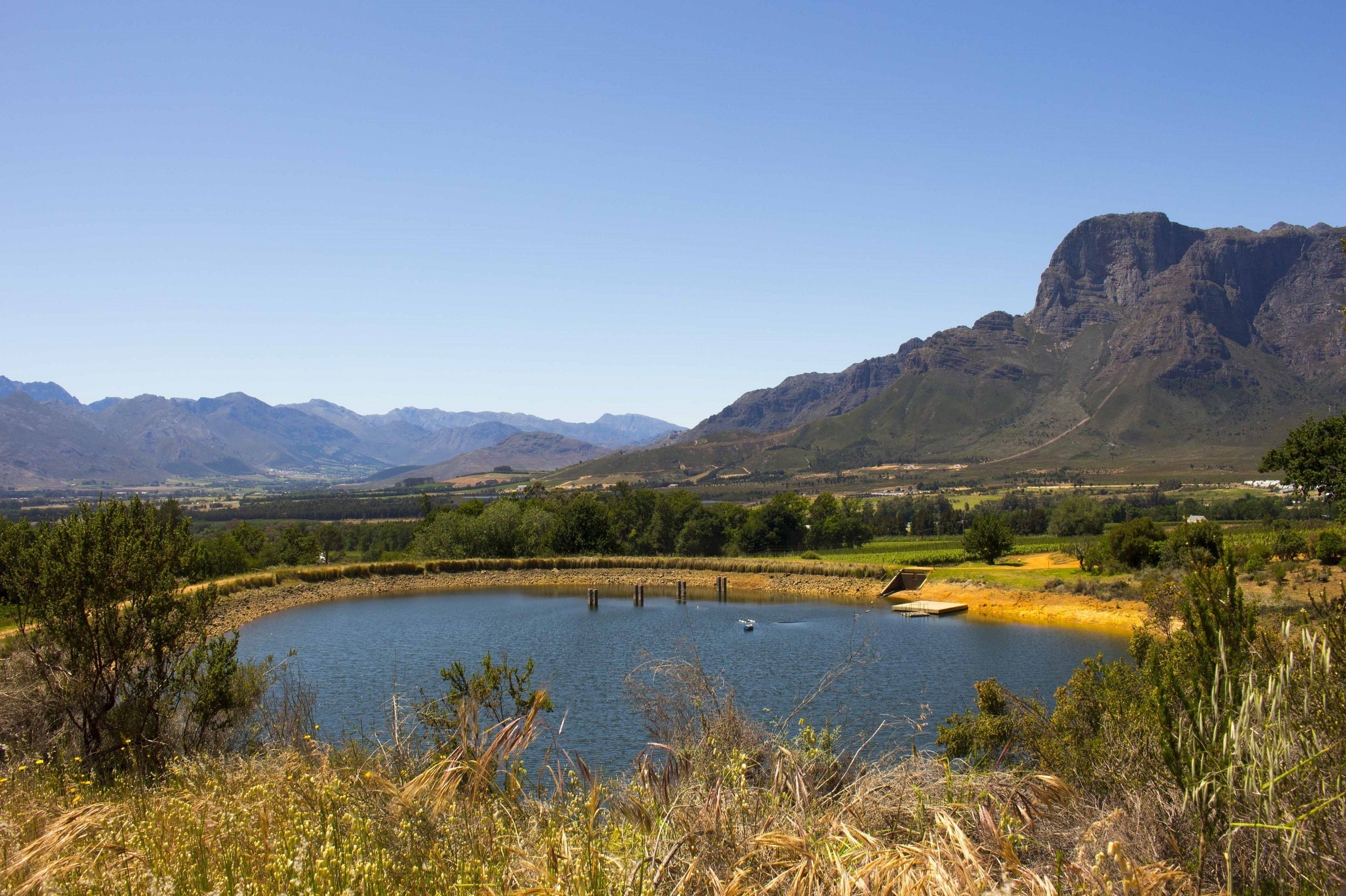 A lake surrounded by mountains and greenery.