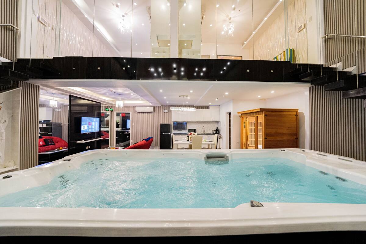 Une piscine intérieure moderne avec vue sur un restaurant et un espace cuisine.