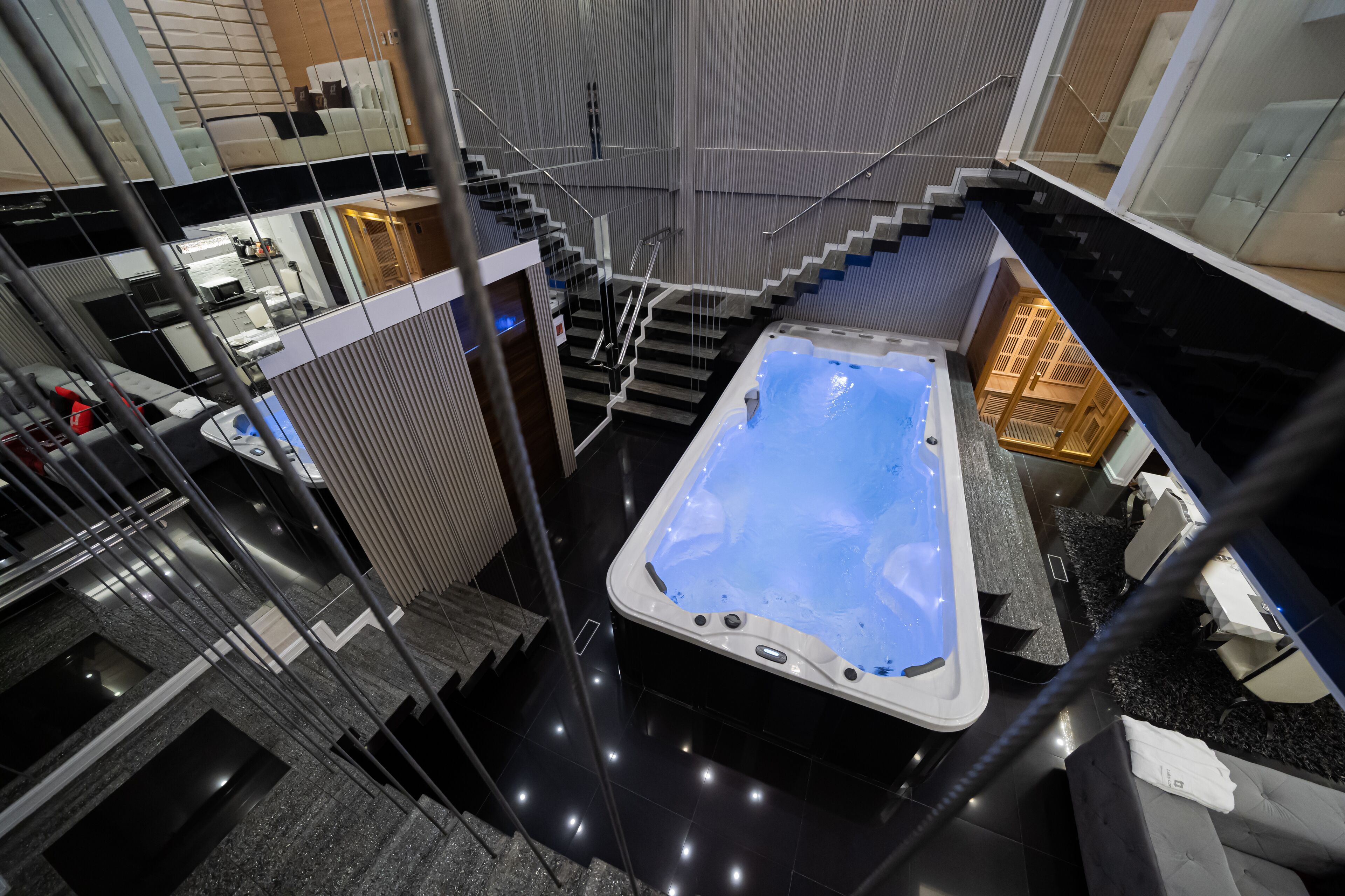 Um interior moderno com hidromassagem, escada e área de cozinha.
