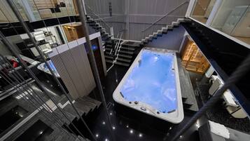 Um interior moderno com hidromassagem, escada e área de cozinha.