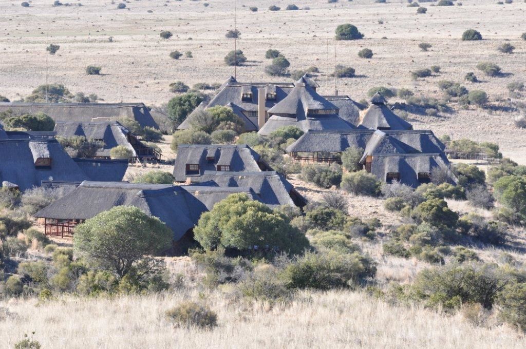 A cluster of thatched-roof houses in a rural setting.