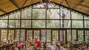 A spacious dining area with large windows, wooden tables, and chairs. - Montpellier De Tulbagh (Tulbagh)