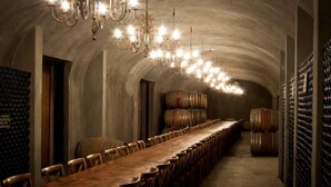 A long wooden table with chairs in a dimly lit room with a vaulted ceiling and chandeliers. - Montpellier De Tulbagh (Tulbagh)