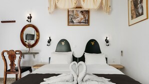 Een hotelkamer met een bed, een spiegel, een schilderij en een kroonluchter.