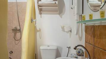 Une salle de bain équipée d’une douche, de toilettes, d’un lavabo et d’un espace pour ranger les serviettes.