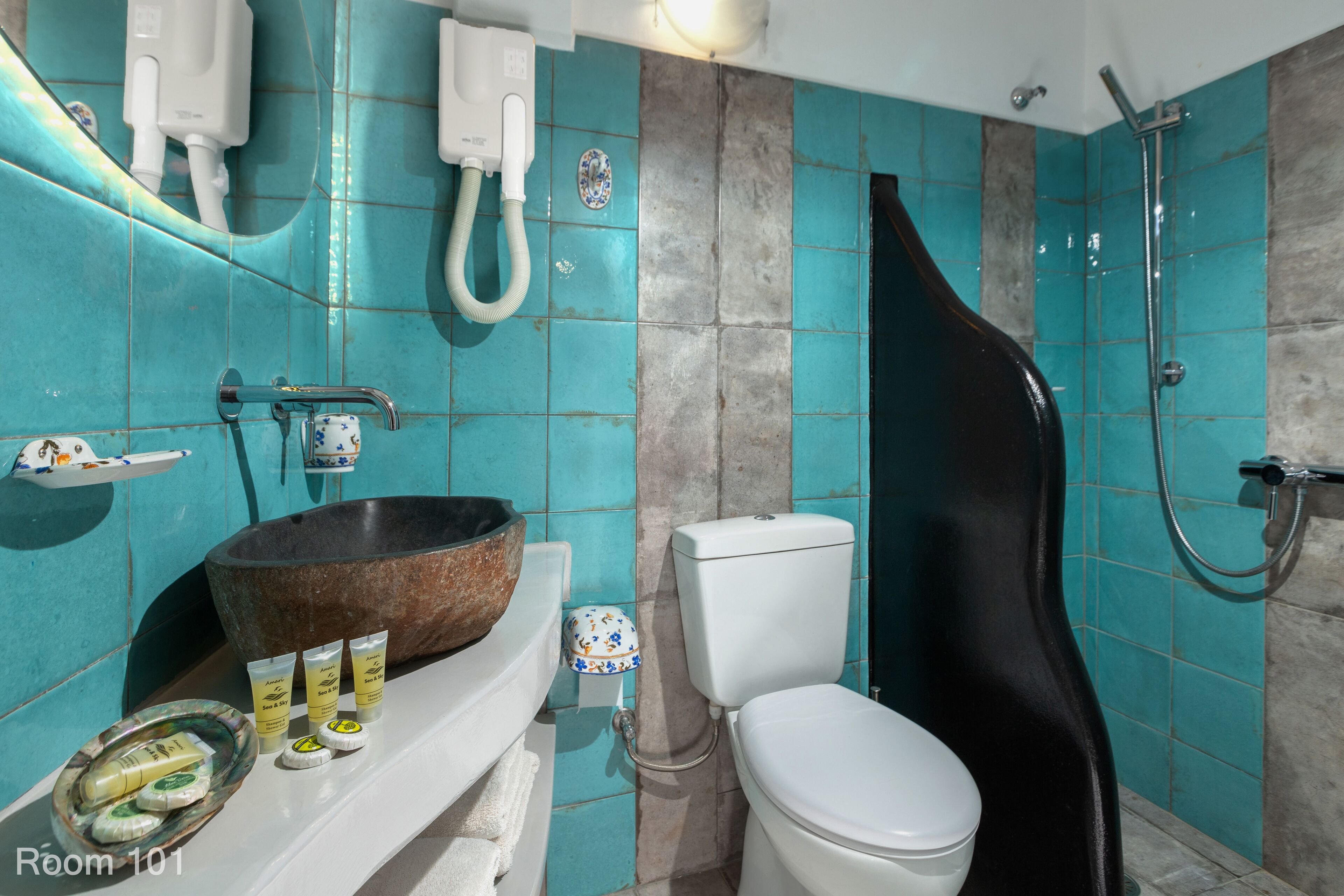 Et badeværelse med stor vask, toilet og brusebad.