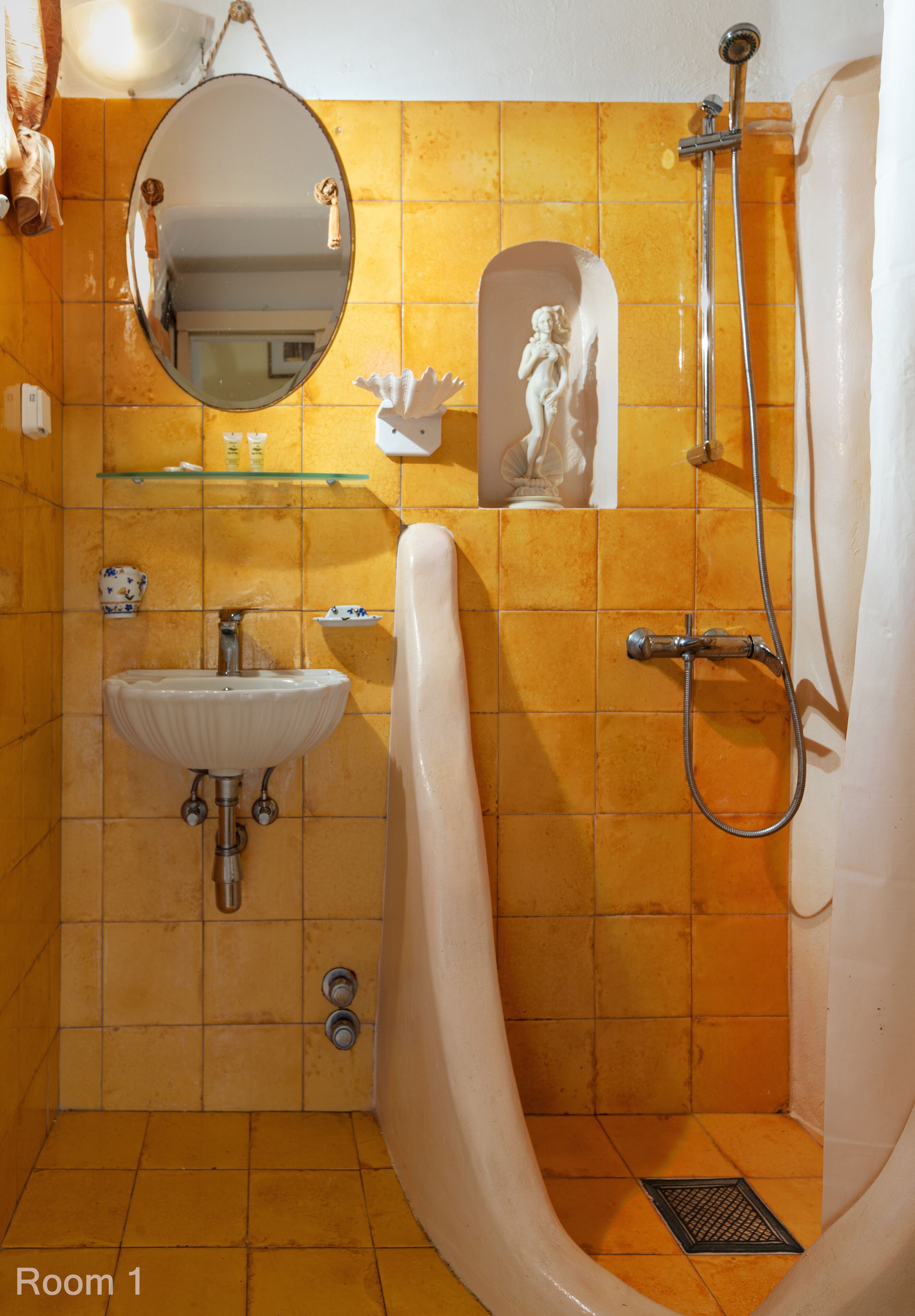 A bathroom with a sink, mirror, shower, and decorative items.