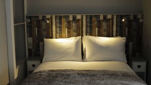 Un dormitorio con una cama, dos mesitas de noche y un cabecero con listones de madera verticales.