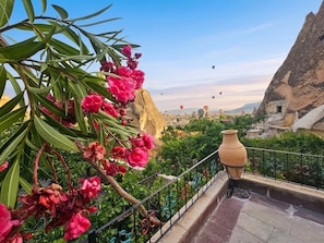 A balcony with a view of a mountainous landscape, a large vase, and a railing. - Roc Of Cappadocia (Nevsehir)