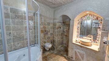 Une salle de bain avec une baignoire, une douche et un lavabo agrémenté d’un miroir en mosaïque.