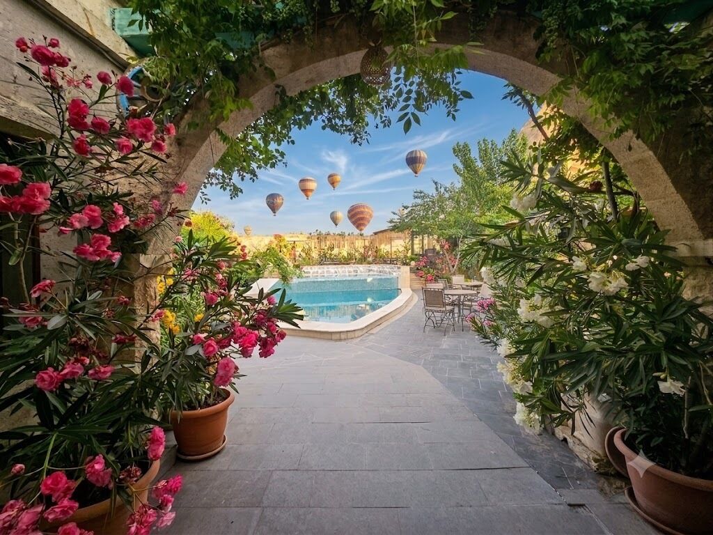 An outdoor pool area with a stone pathway, potted plants, and a clear view of the pool.