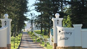 A pathway leading to a building with a sign reading "Rearsney Manor". - Kearsney Manor Guesthouse (KwaDukuza)