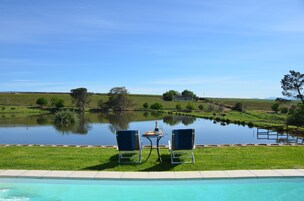Una piscina al aire libre, sillones reclinables de piscina
