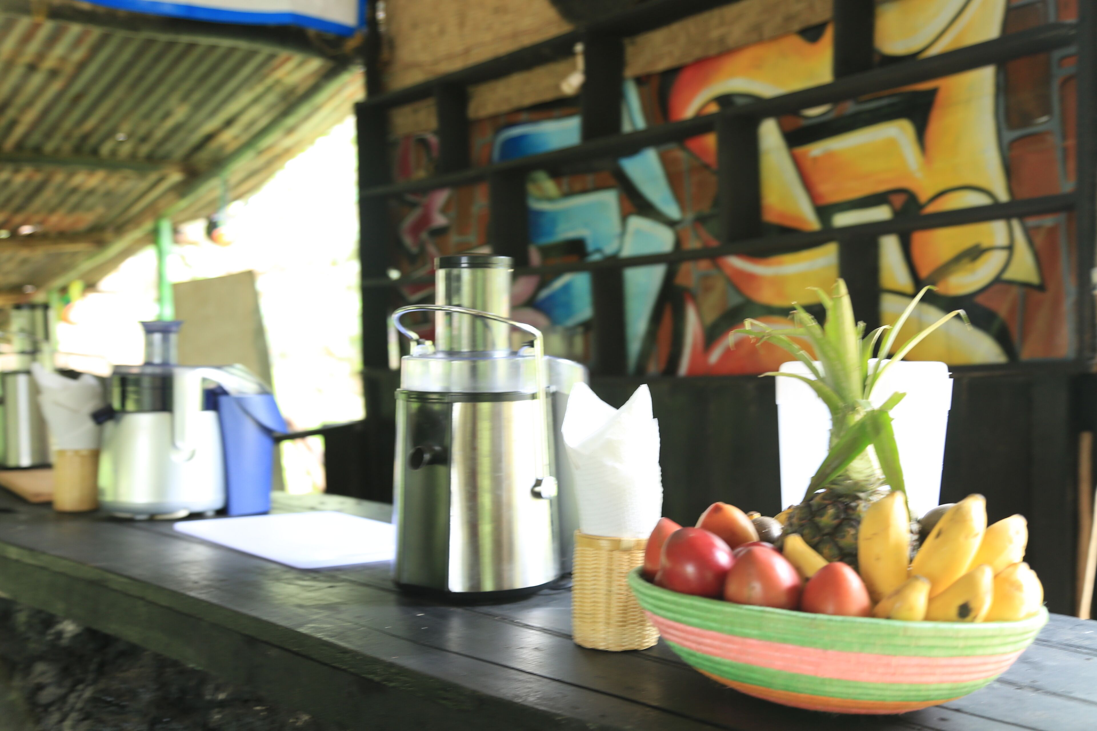 Een tafel met een thermoskan, een fruitschaal en een koffiezetapparaat.
