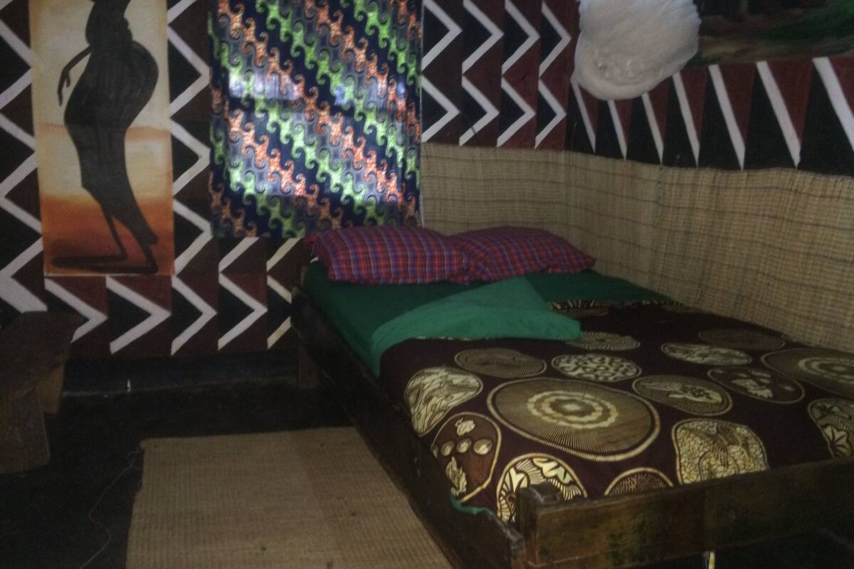 A room with a bed, a patterned wall, and a hanging light fixture.