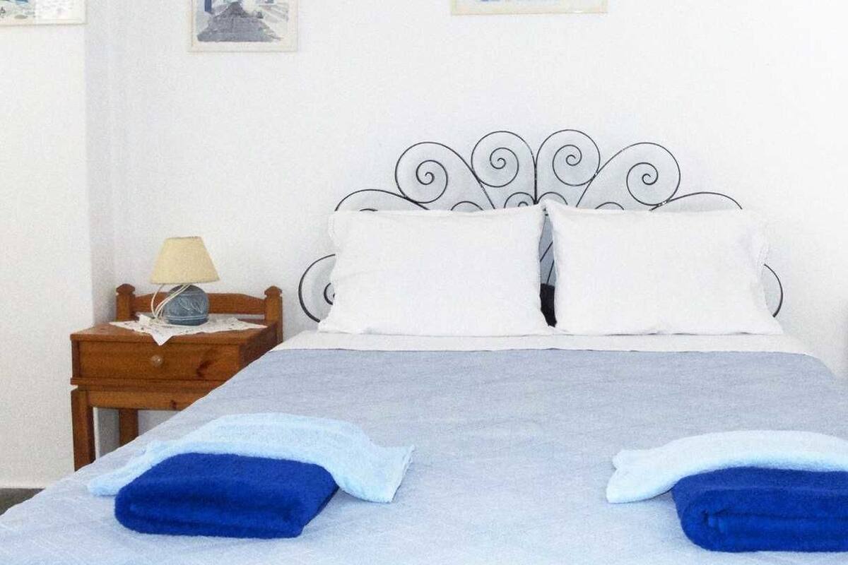 A bed with a metal headboard, two pillows, and two nightstands with lamps.