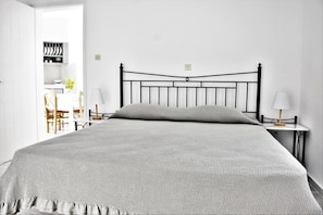 Ein Schlafzimmer mit einem Bett, zwei Nachttischen, einer Lampe und einem Kleiderschrank.