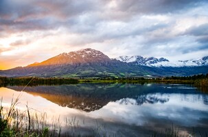 A tranquil lake with a mountain range in the background.