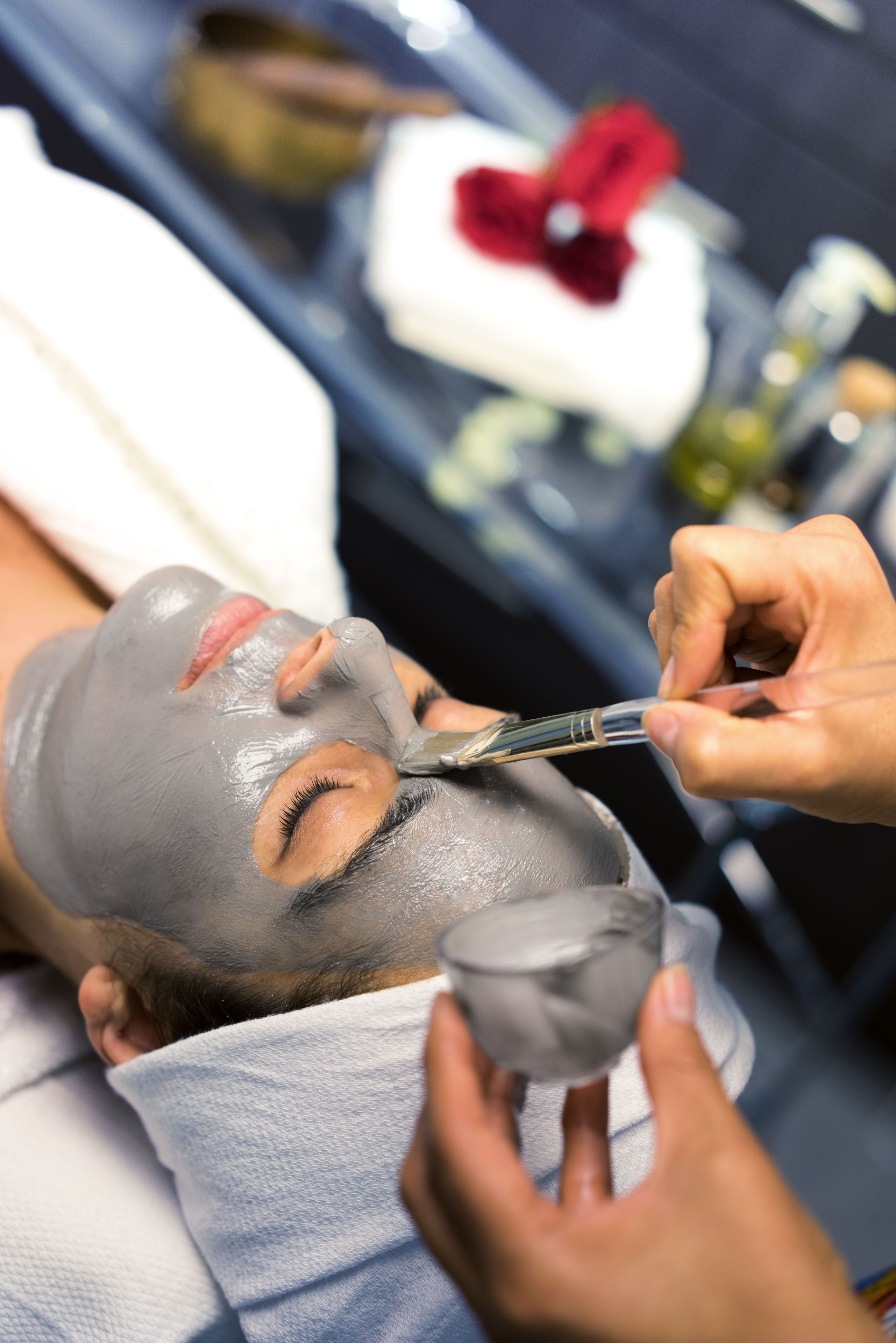 Una persona recibiendo un tratamiento facial con una máscara gris.