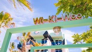 Un edificio con un cartello che riporta "Wi-Ki-Woo" e un design architettonico moderno, caratterizzato da balconi e ampie finestre.