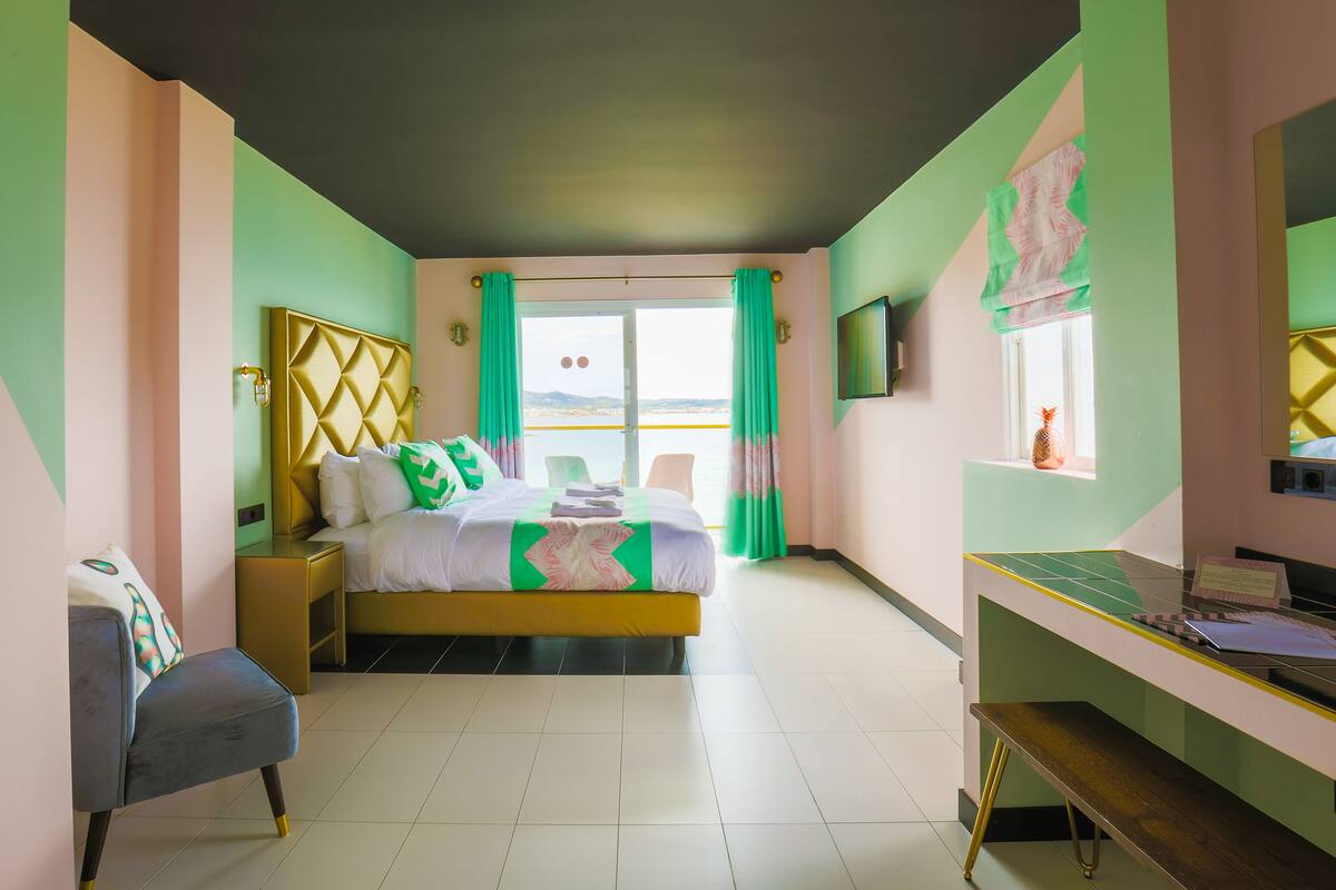 A bedroom with a bed, a desk, and a chair.