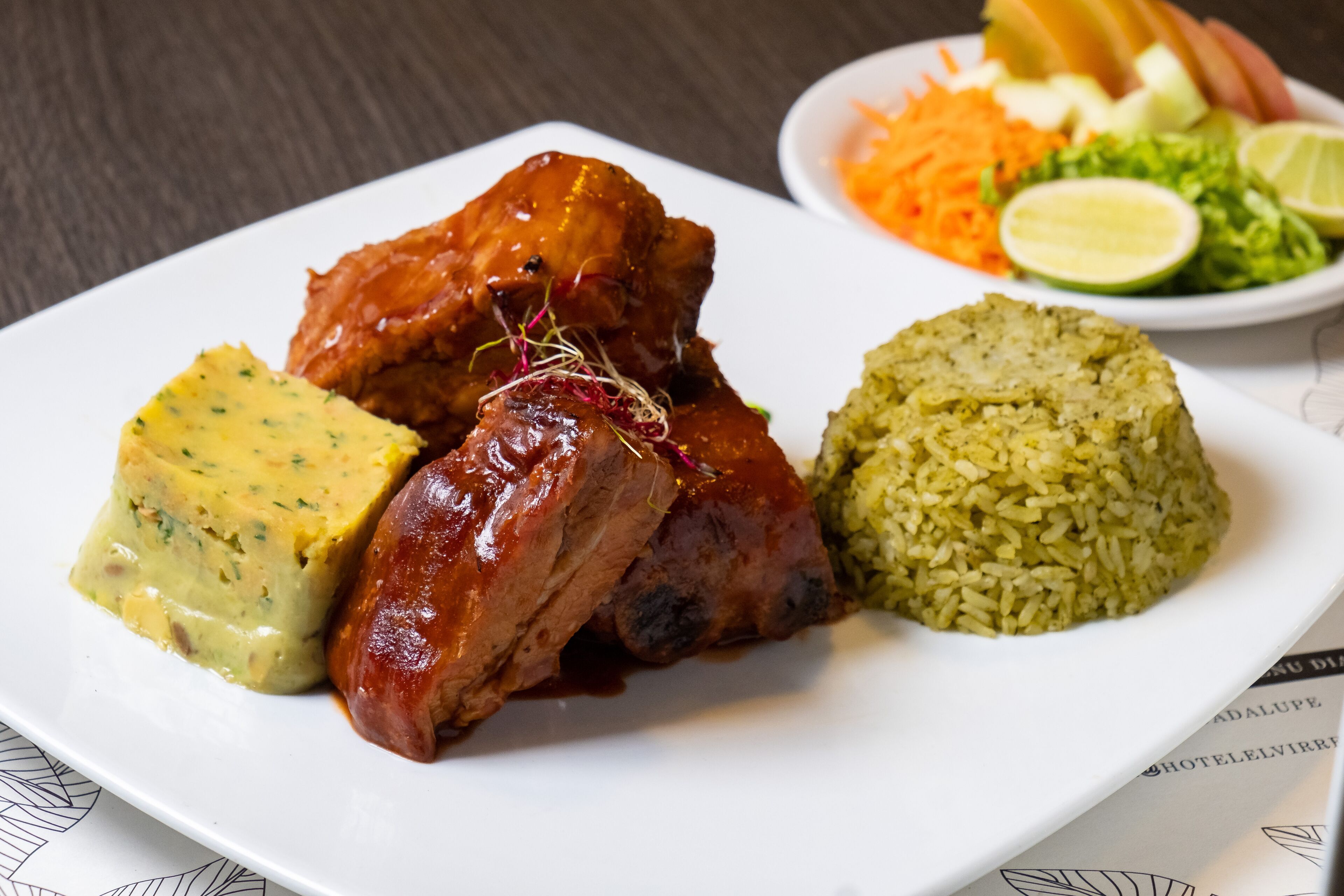 Ein Teller mit Fleisch, Reis und einer Beilage.