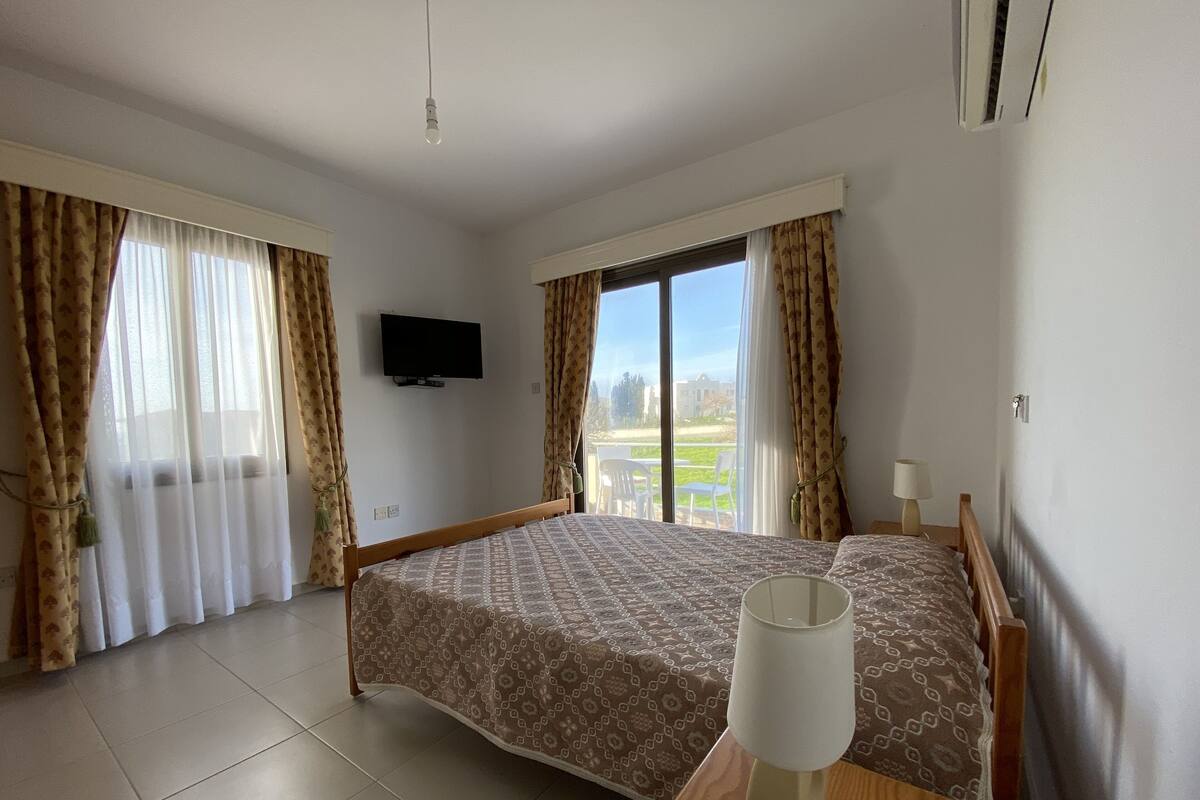 Une chambre d’hôtel avec un lit, une télévision et une vue sur l’extérieur.