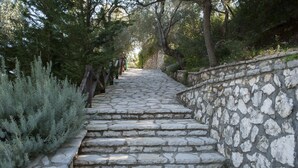 A stone staircase surrounded by trees and shrubs. - Arethousa Villas (Lefkada)