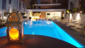 Ein Poolbereich mit Laterne und einer Bar im Hintergrund.