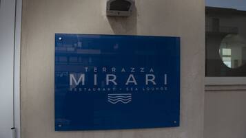 A blue sign for 'Terrazza Mirari Restaurant & Sea Lounge' mounted on a wall.