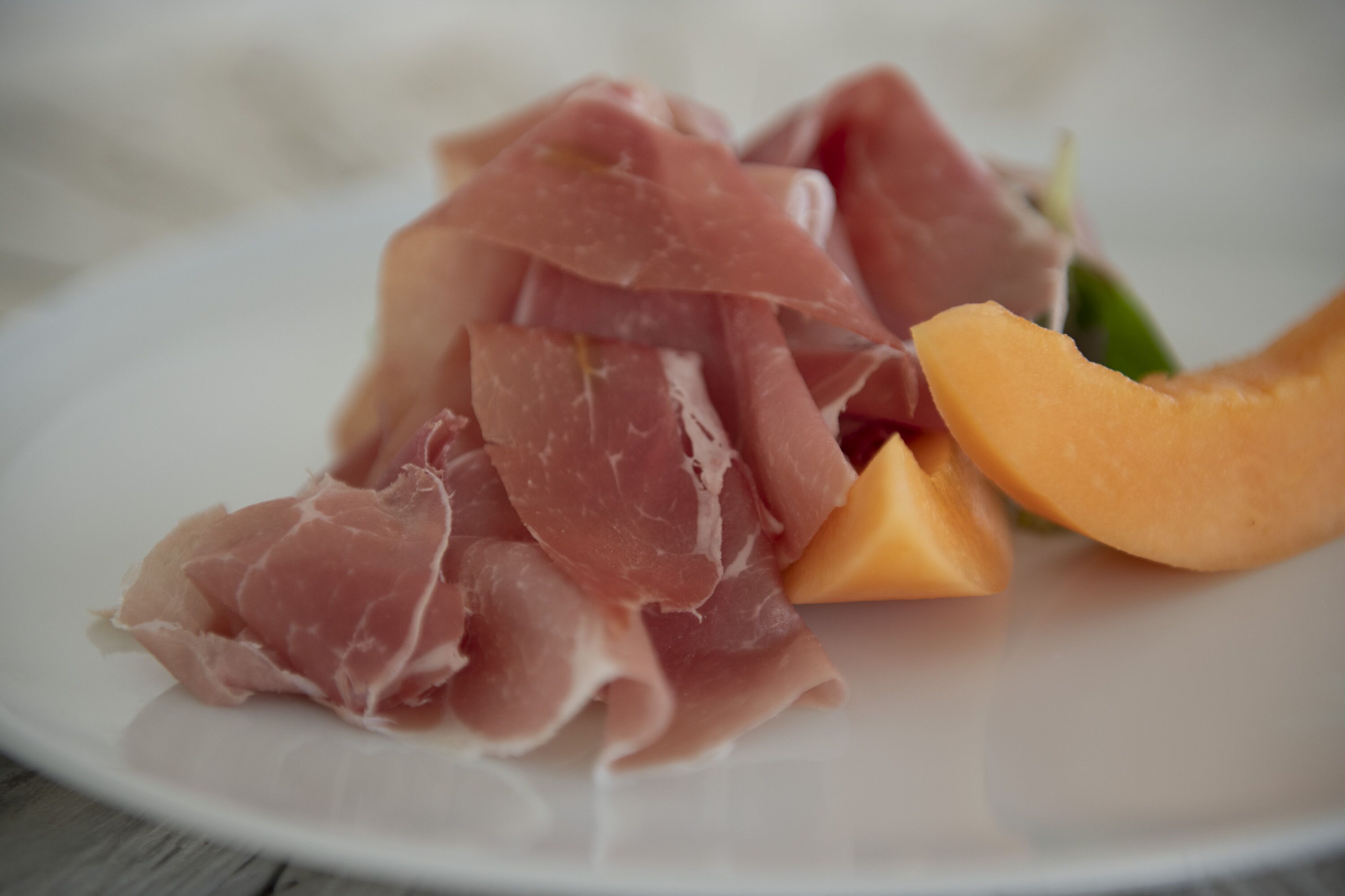 Ein Teller mit Parmaschinken und Melonenscheiben.