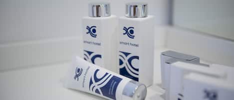 Presentación de artículos de aseo con el logotipo de 'Smart Hotel', que incluye un tubo de loción y dos botellas de champú.