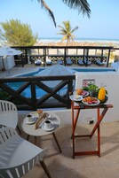 Una terraza con piscina, mesa de comedor, sillas y un cartel que indica que no se permite el alcohol.