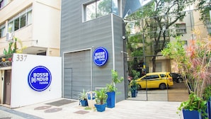 A modern hotel with a blue sign, potted plants, and a yellow car parked outside. - Samba Bossa Nova Ipanema (Rio de Janeiro)
