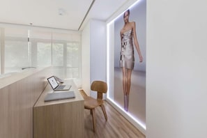A modern office with a desk, chair, and a large poster of a model. - Samba Bossa Nova Ipanema (Rio de Janeiro)